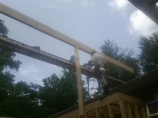 Carpenter setting a ridge beam over a new addition frame — Ice Dam Removal by Roofing Brothers in Colfax