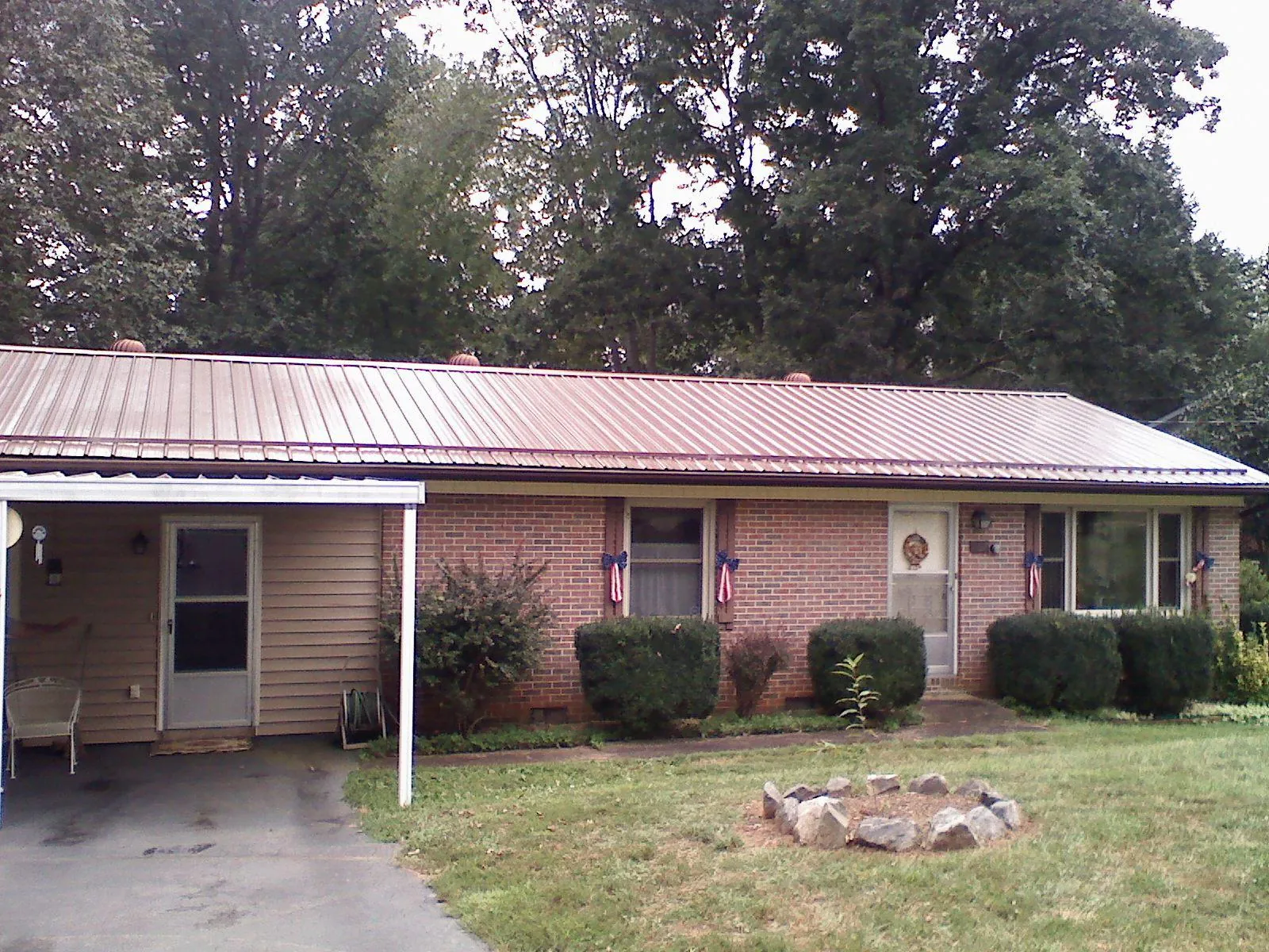 Bronze metal roof and carport on a brick ranch home — Roof Repair work by our crew in Colfax